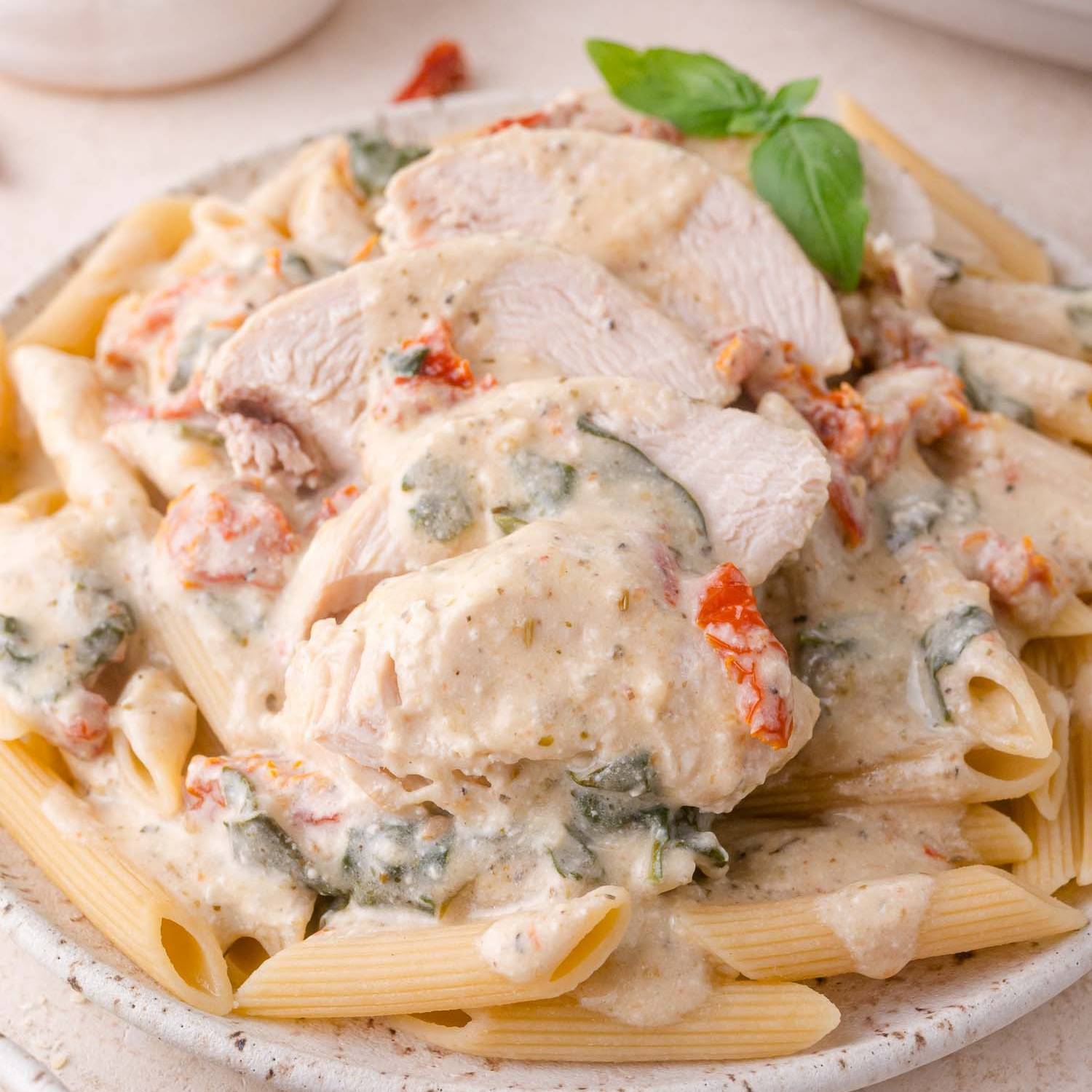 Sliced chicken in a creamy sauce, served on top of penne pasta.