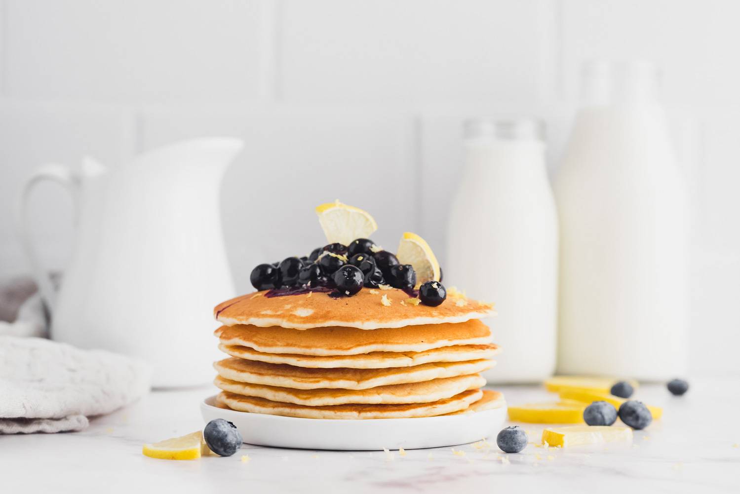 Stack of lemon blueberry pancakes topped with blueberry sauce.