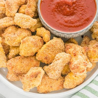 Chicken nuggets on a platter with marinara sauce.