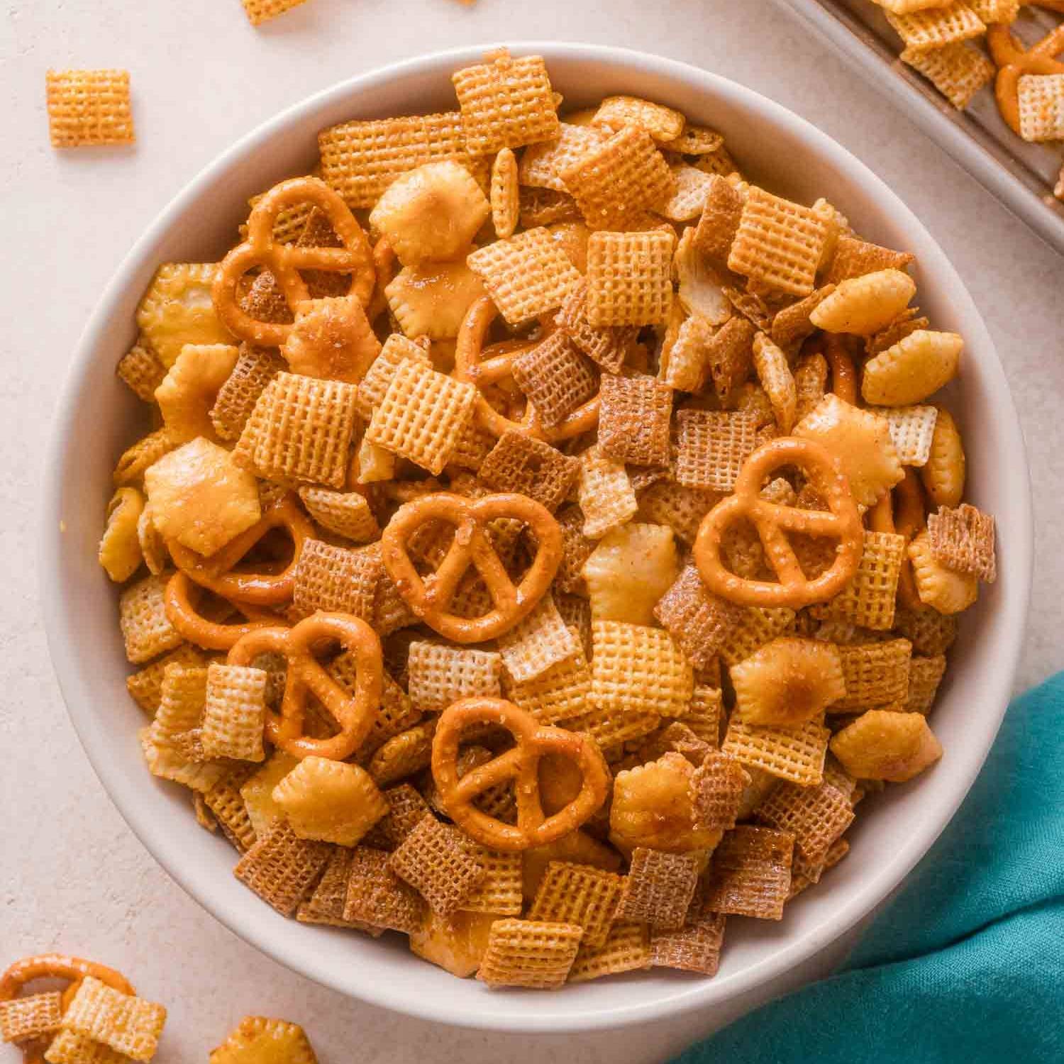 Hot honey chex mix in a bowl, featuring chex cereal, pretzels, and oyster crackers.