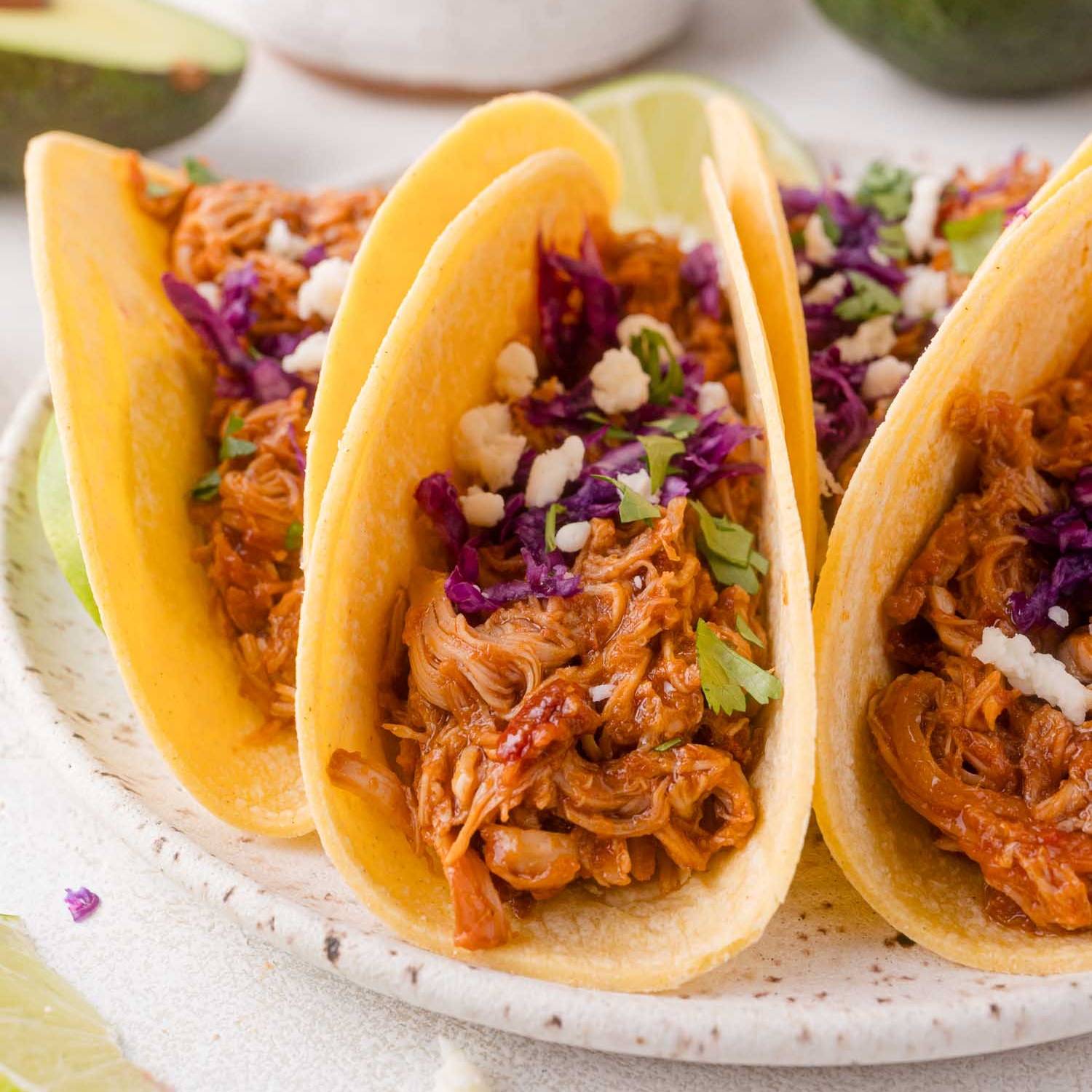 Three chipotle chicken tacos in corn tortillas.