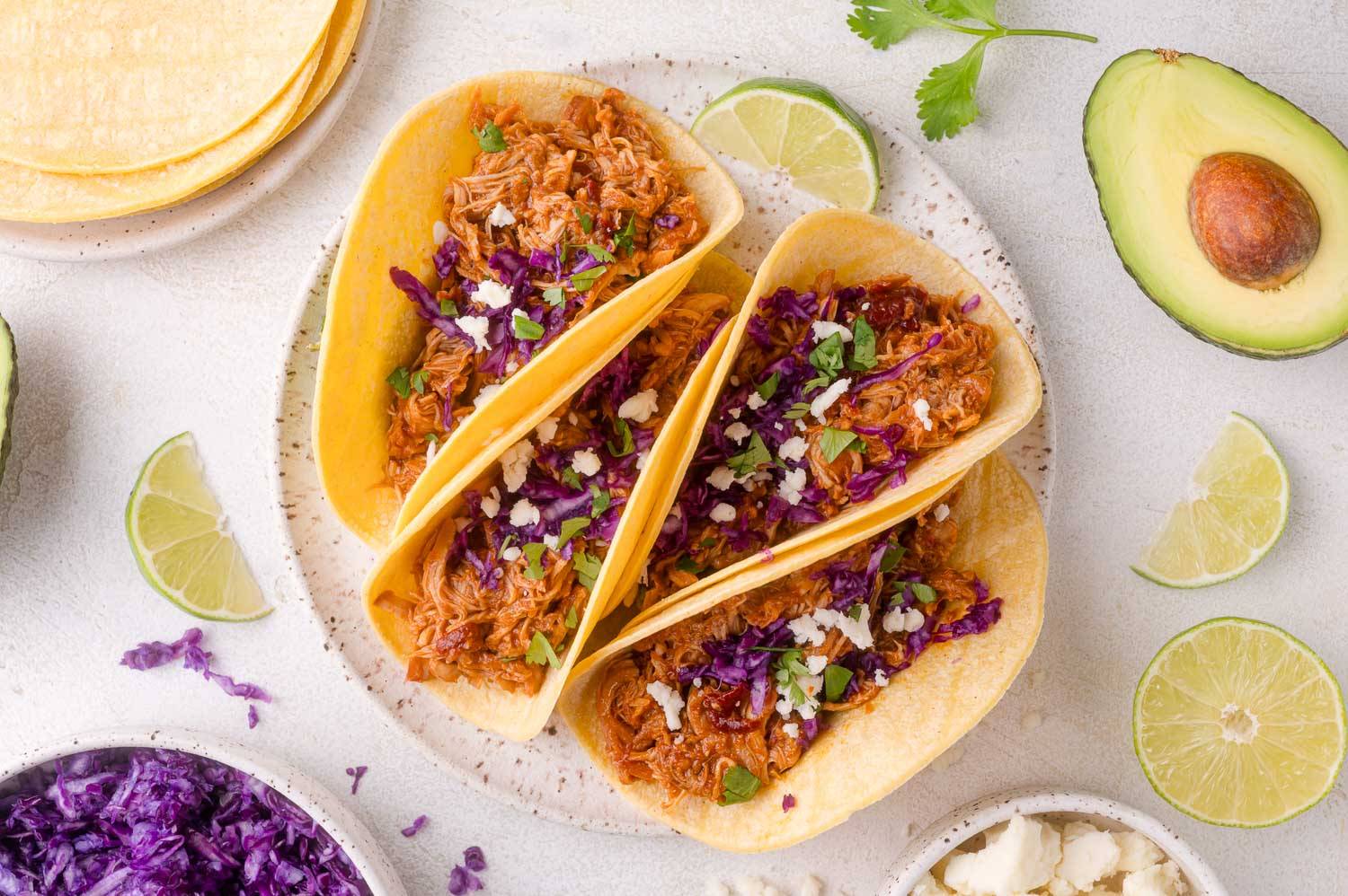 Four chipotle chicken tacos on a plate.