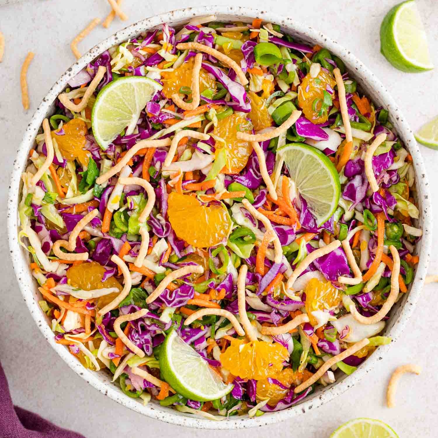 Cabbage salad with chow mein noodles, limes, green onion, and mandarin oranges.