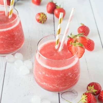 Frosé in a stemless glass with two striped straws.