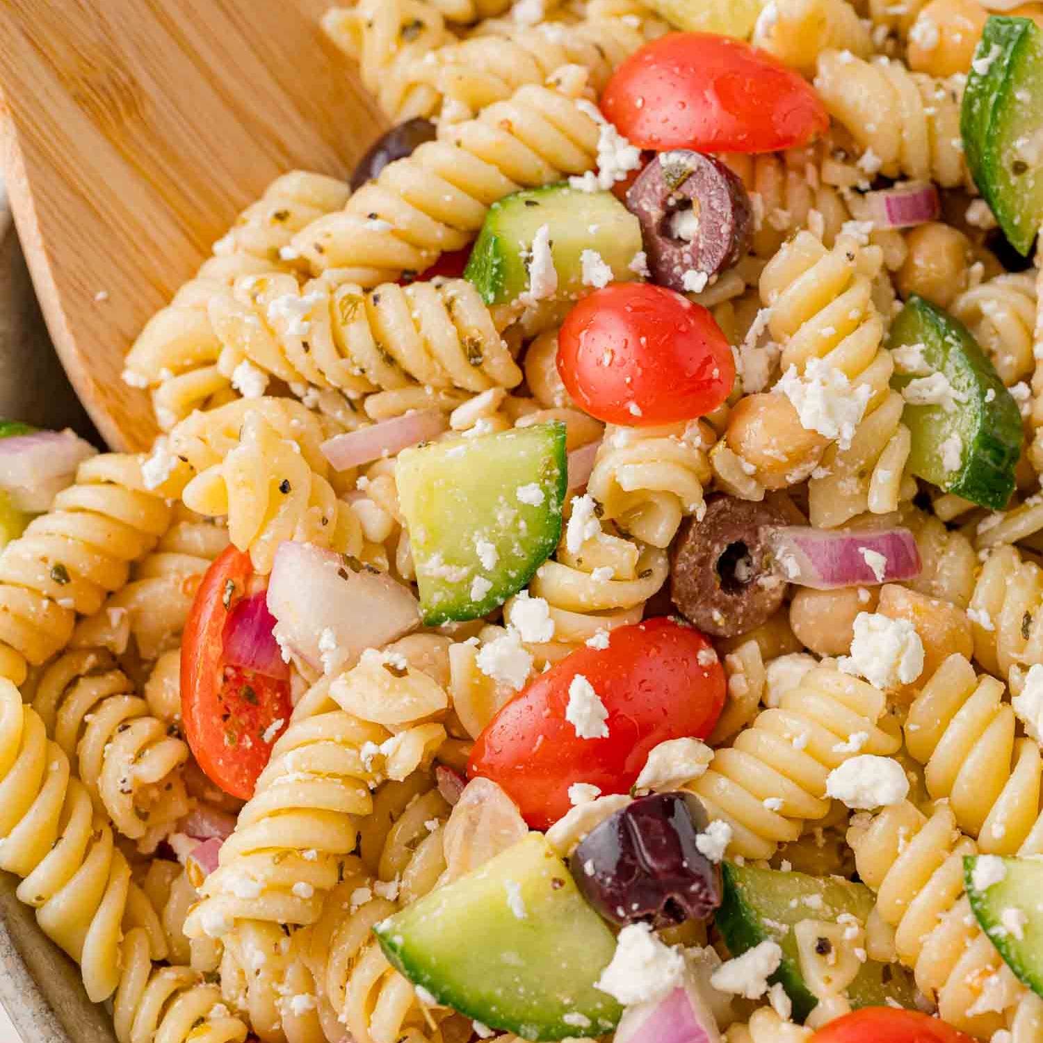 Greek pasta salad with rotini pasta, cucumber, tomato, and olives.