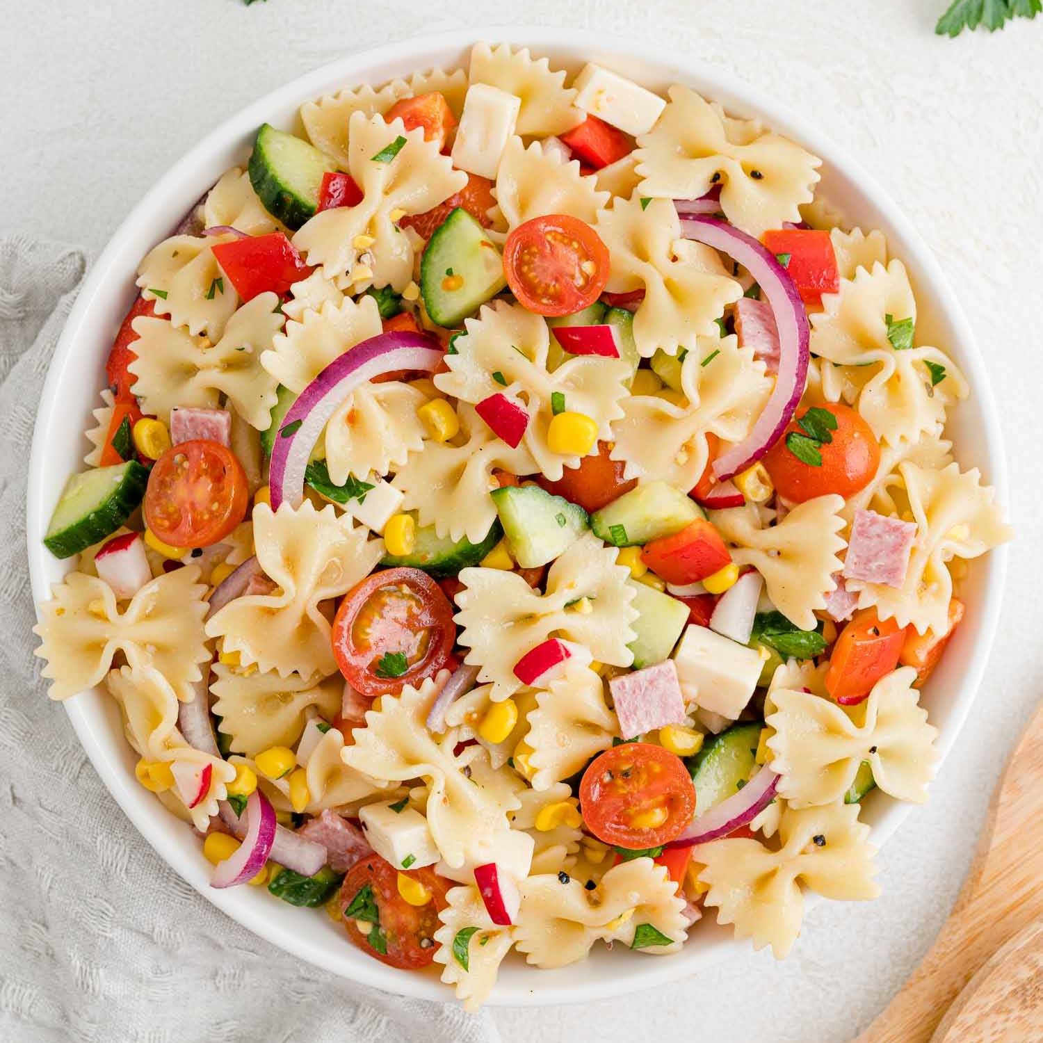 Summer pasta salad in large white bowl.