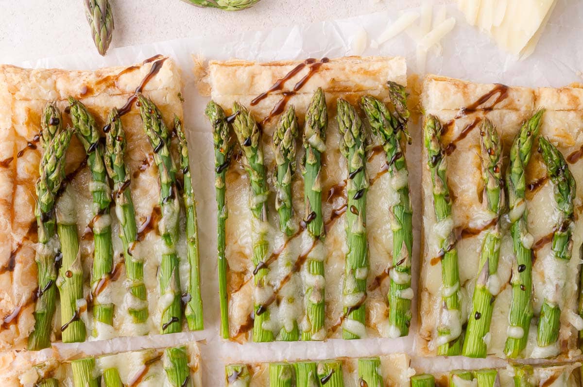 Asparagus tart on puff pastry, with cheese, drizzled with balsamic glaze.