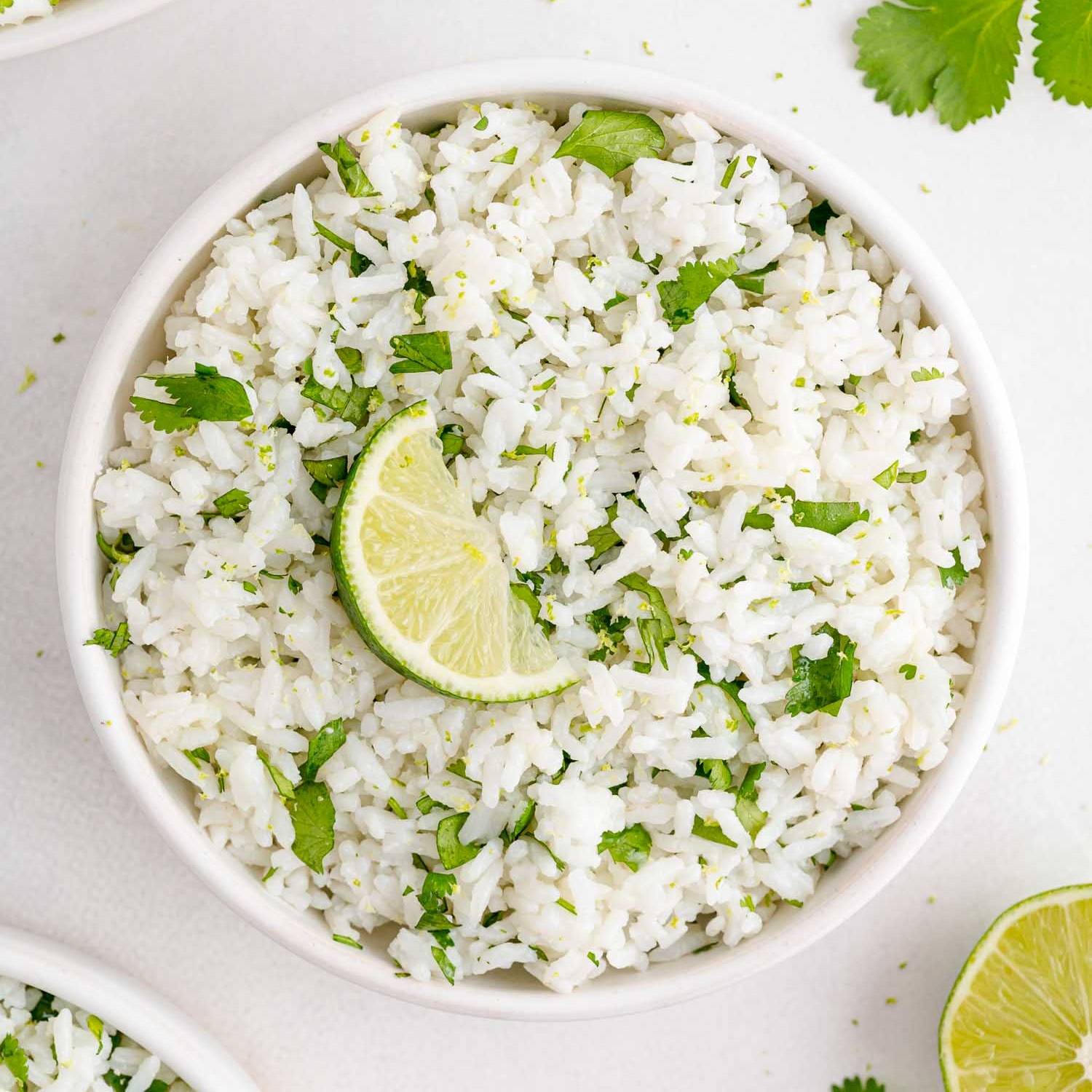 Cilantro lime rice in a bowl with a lime slice top.