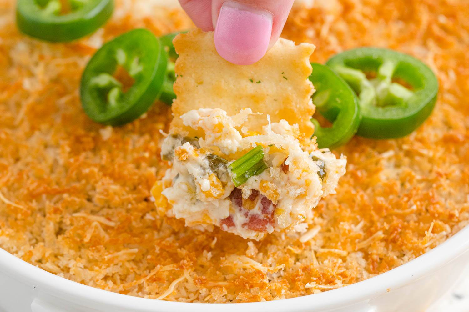 Jalapeno popper dip with a cracker.