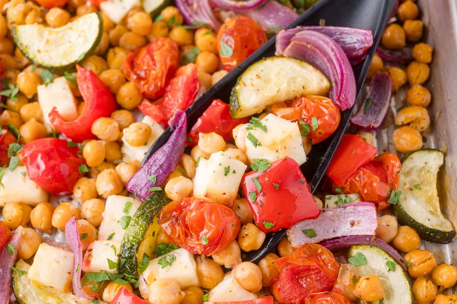 Halloumi cheese, chickpeas, and vegetables on a sheet pan.