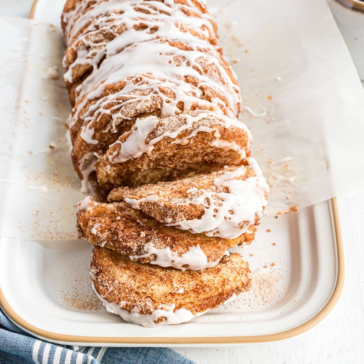 Loaf of cinnamon sugar bread, with layers pulled apart. It is topped with a glaze.