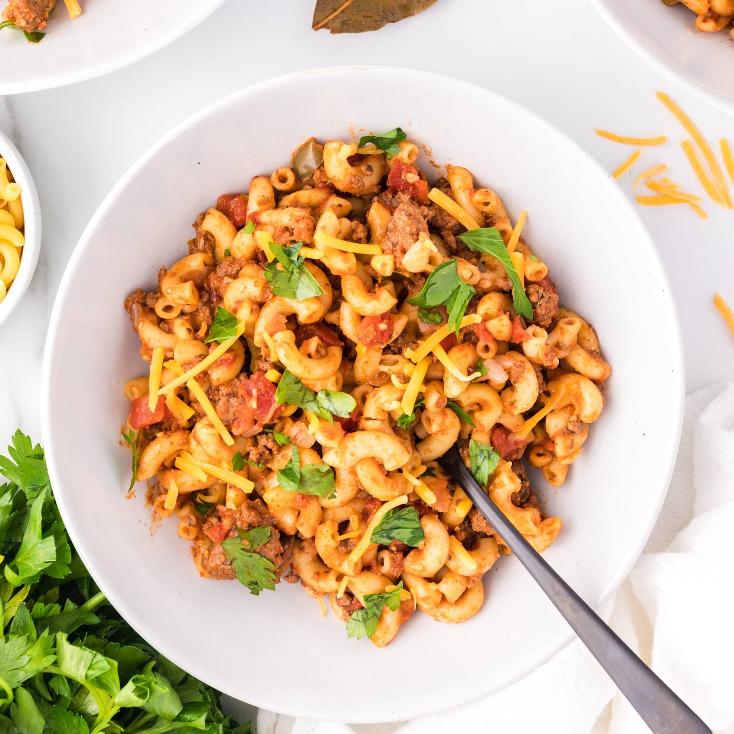 Goulash topped with cheddar cheese and fresh parsley.