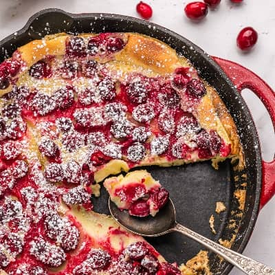 Cranberry clafloutis in a red pan.