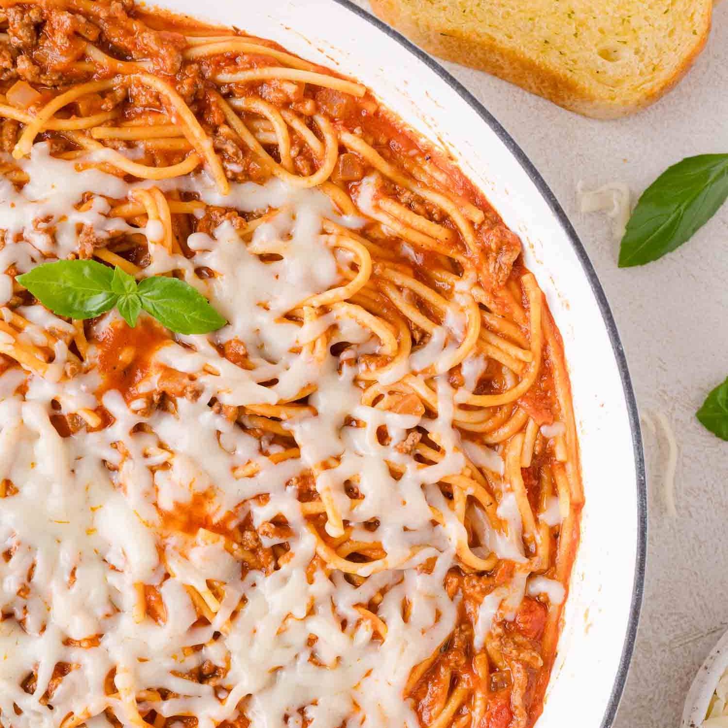 One pan spaghetti with sauce, topped with melted mozzarella cheese.
