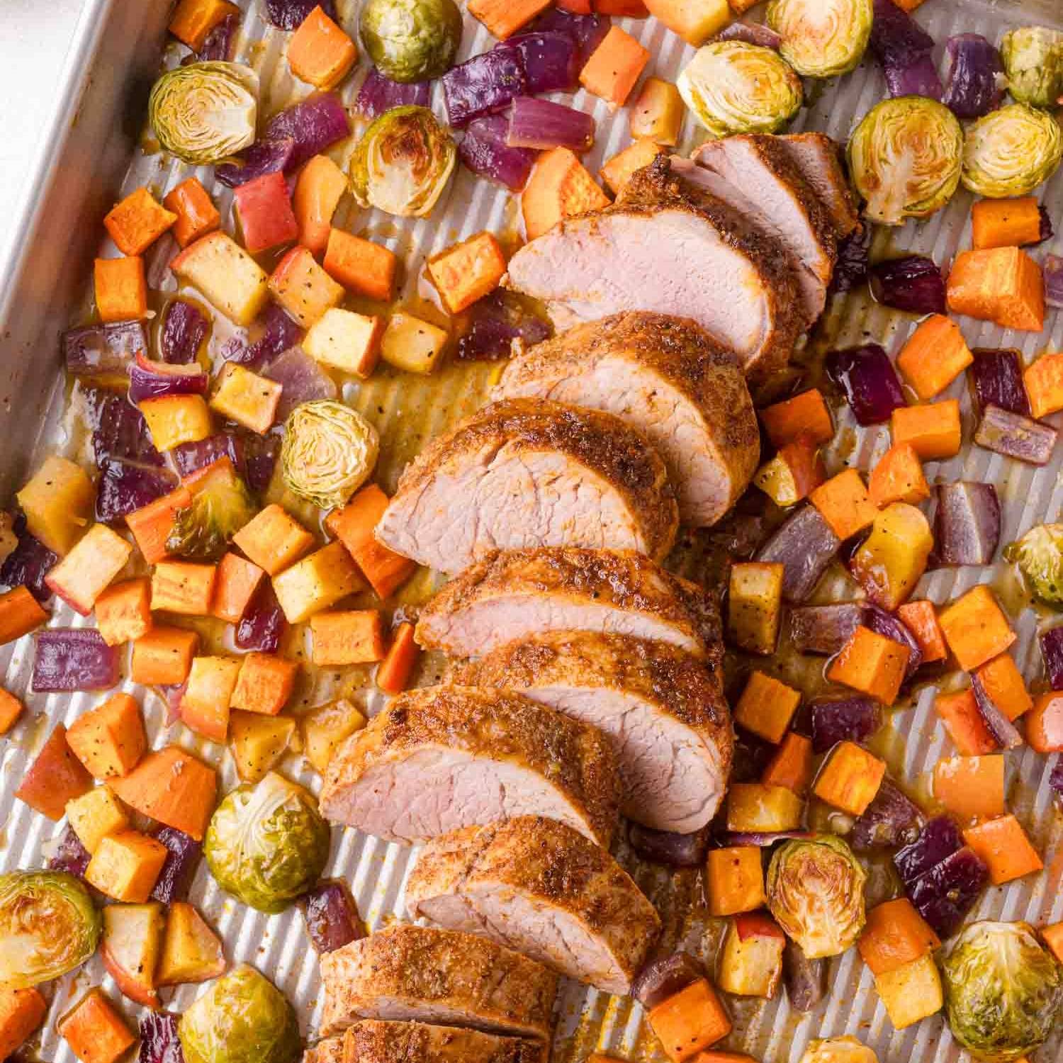 Sheet pan pork tenderloin with vegetables, tenderloin in sliced.