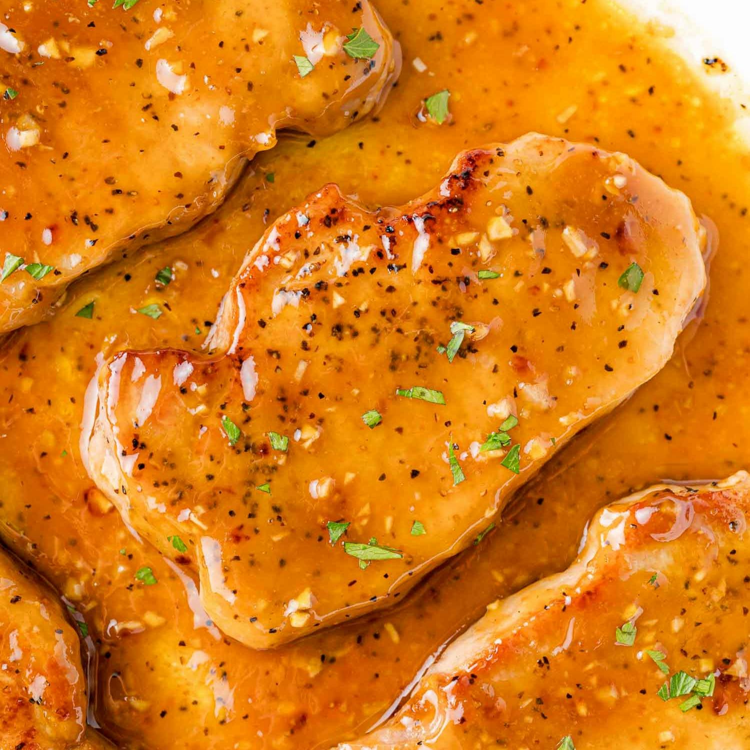 Close up image of a pork chop in honey garlic sauce.