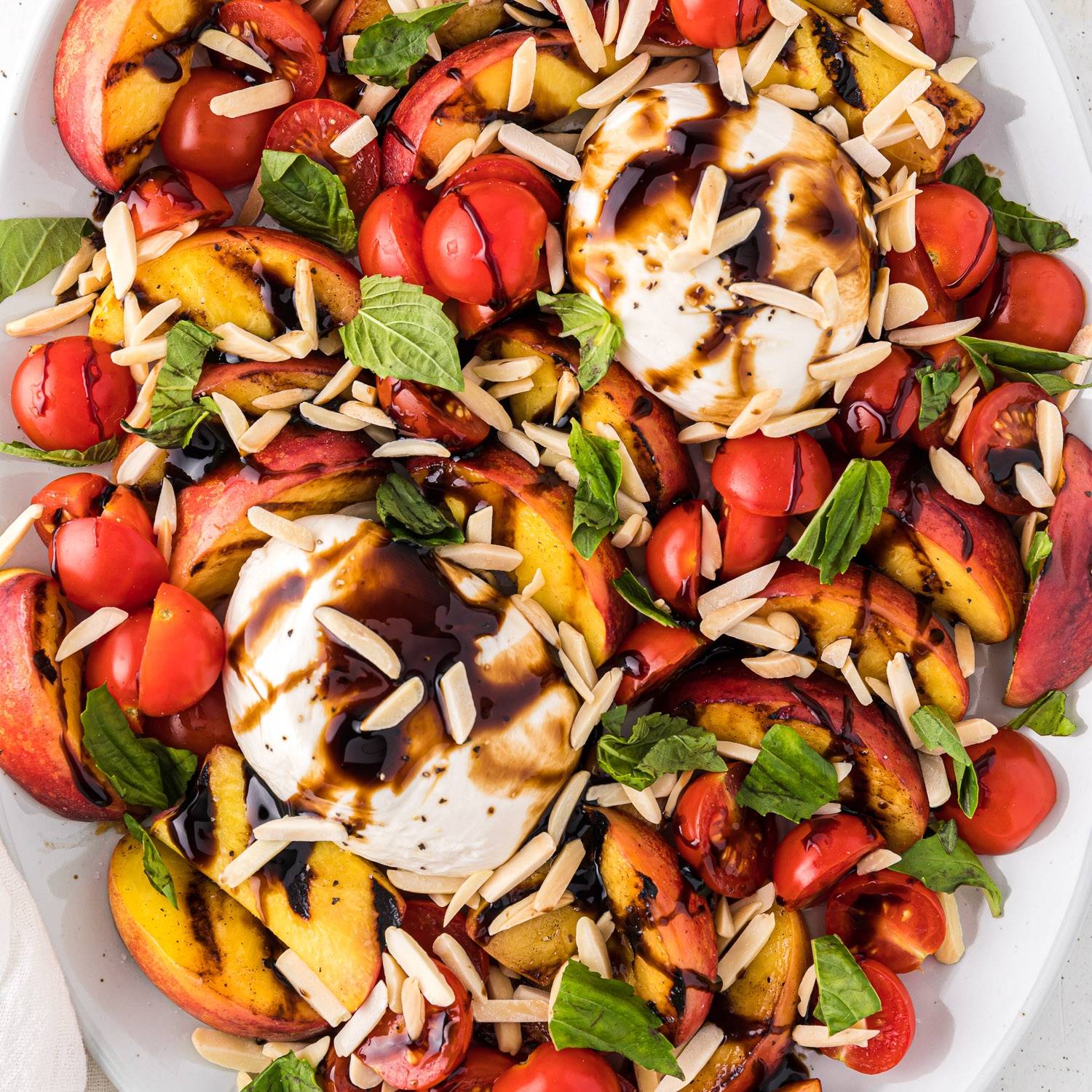 Grilled peaches with burrata, tomatoes, and balsamic glaze.