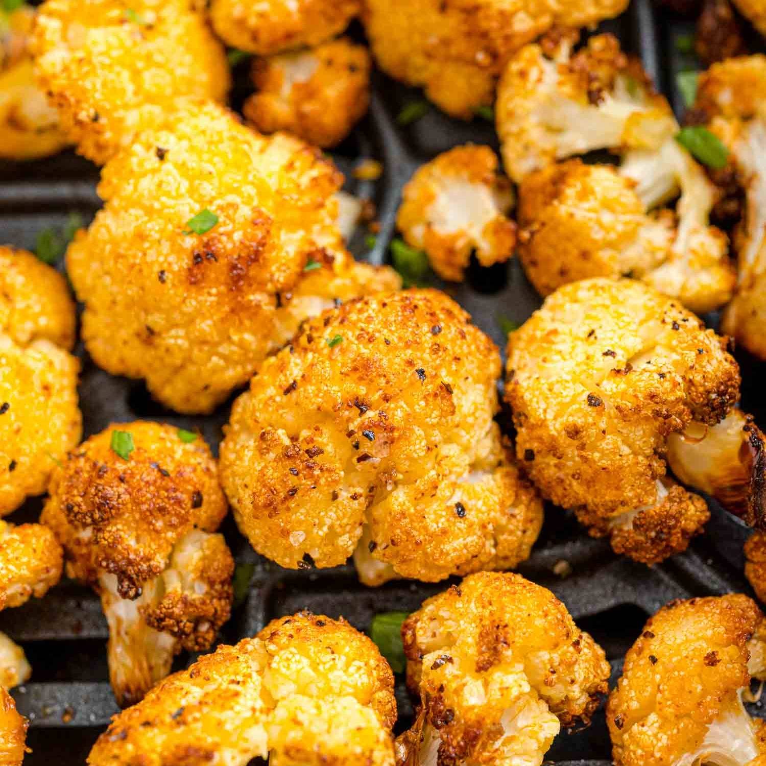 Close up of cauliflower in an air fryer basket.