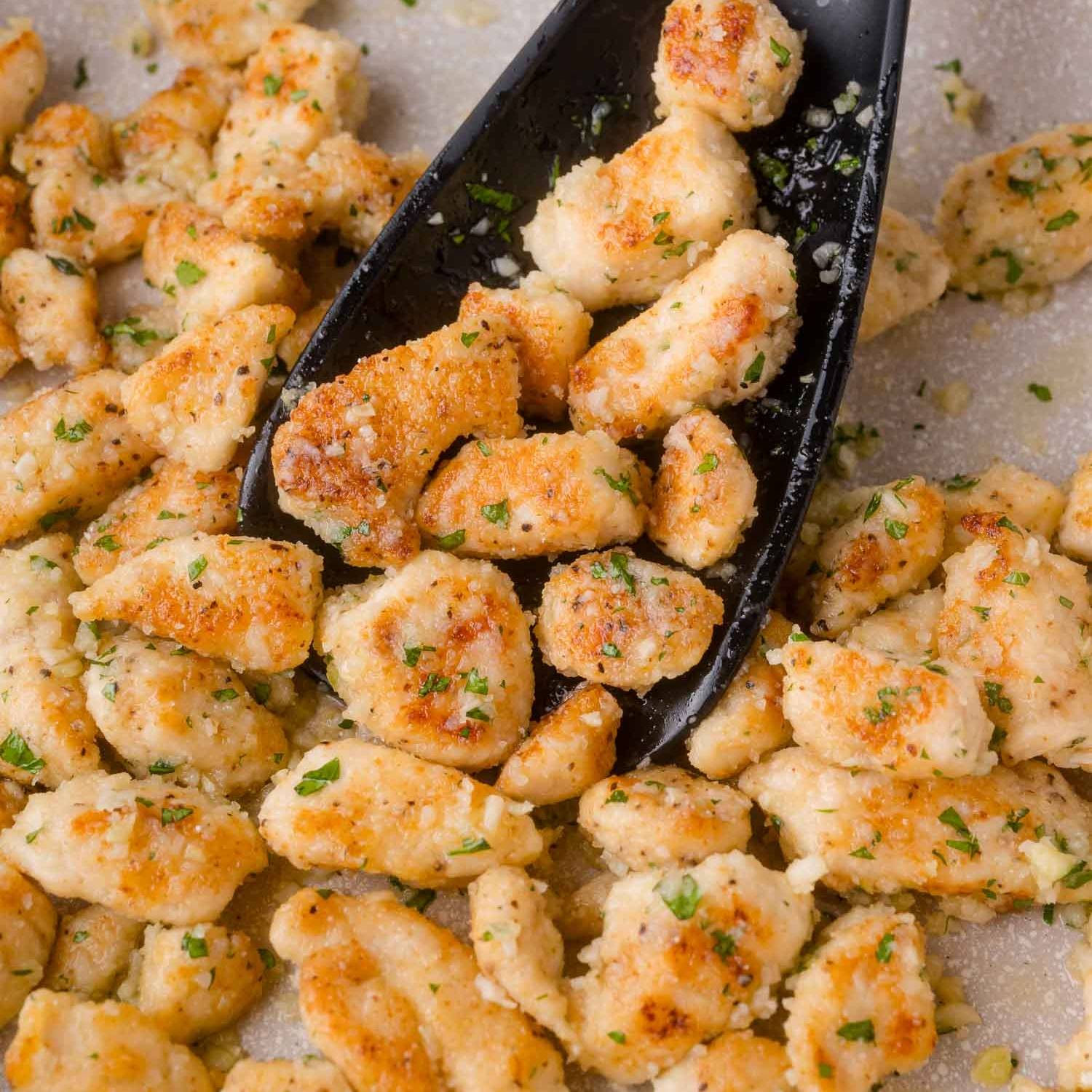 Garlic parmesan chicken bites, sprinkled with fresh parsley.