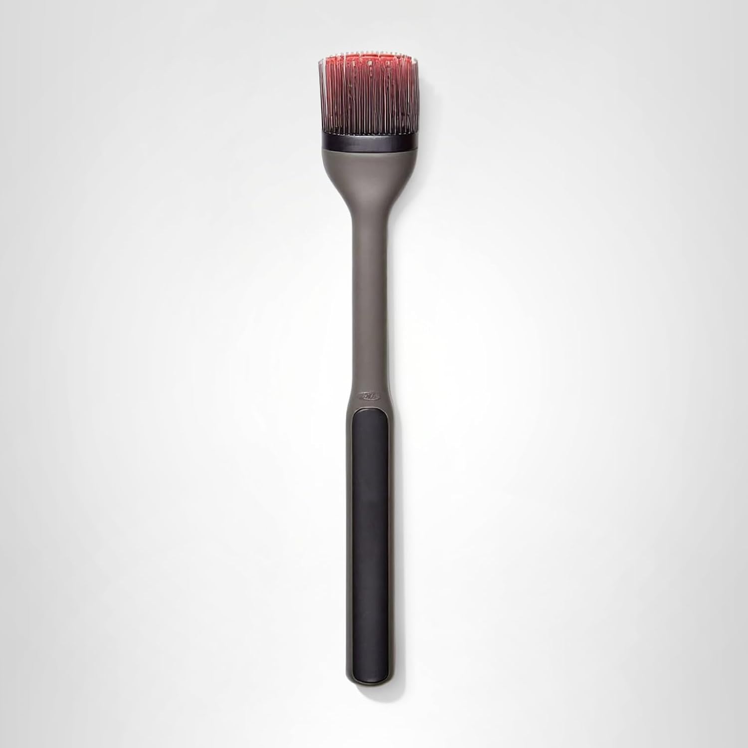 Grill basking brush with a black handle and red bristles..