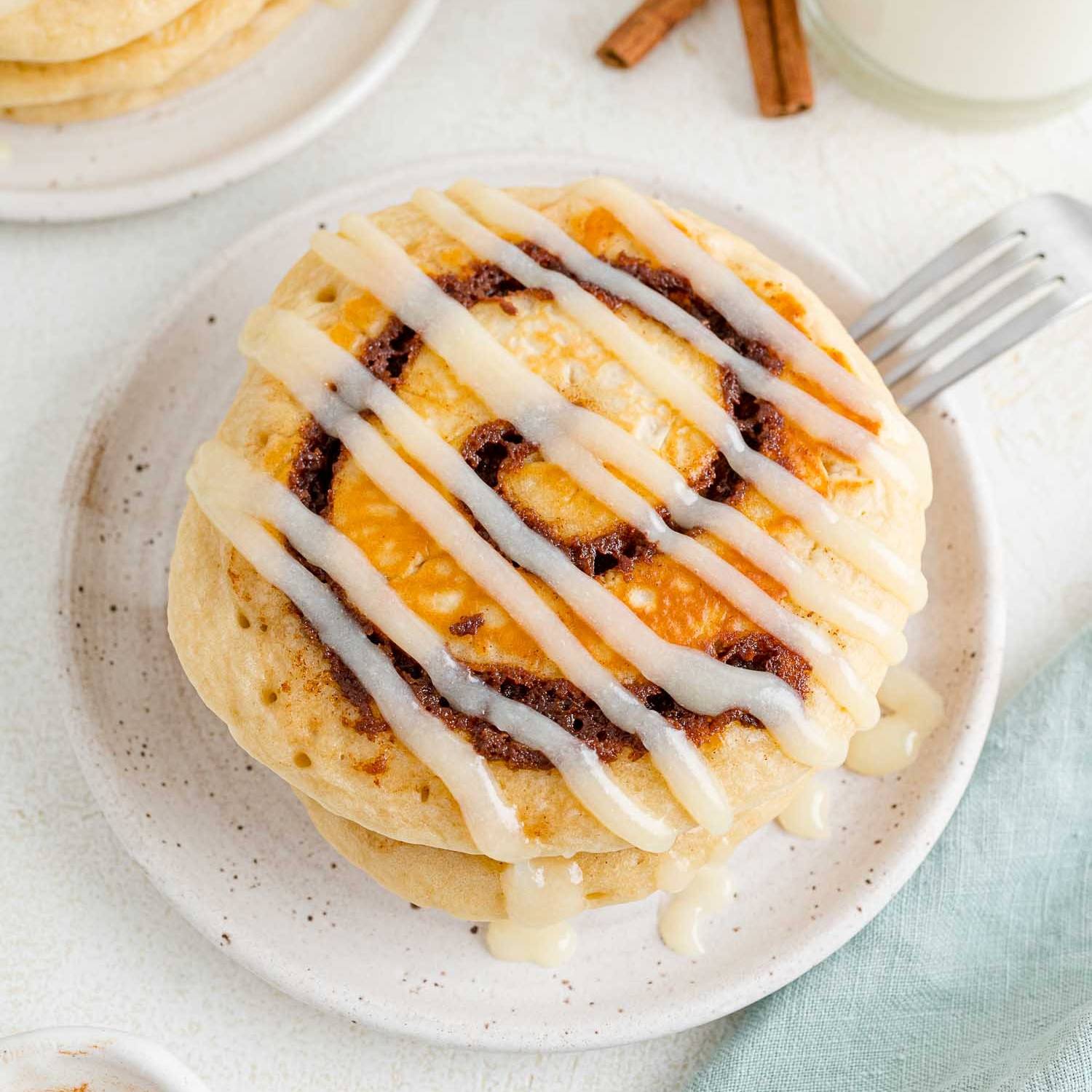 Cinnamon roll pancakes drizzled with glaze.