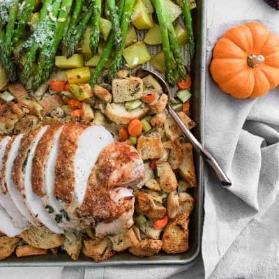 Turkey, dressing, potatoes, and asparagus on a sheet pan.