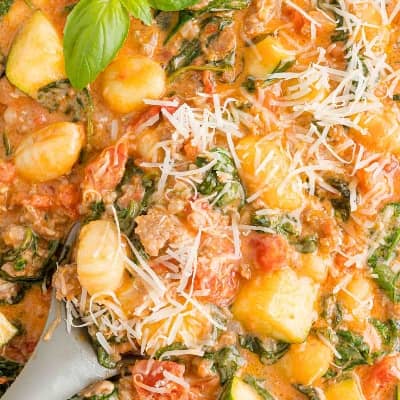 Creamy one pot gnocchi with spinach and zucchini, sprinkled with Parmesan.