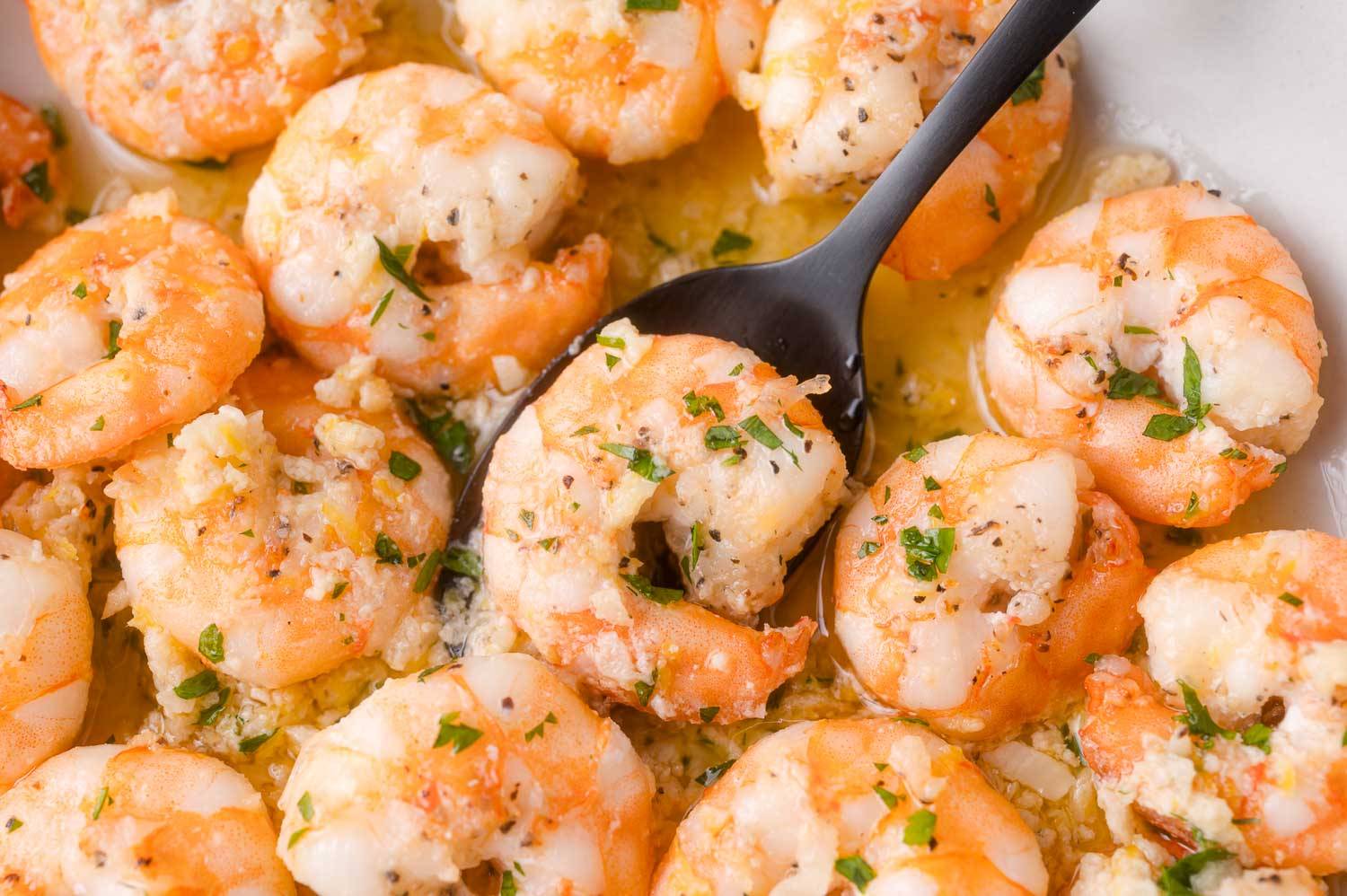 Close up of shrimp scampi with a garlic butter sauce, garnished with parsley.