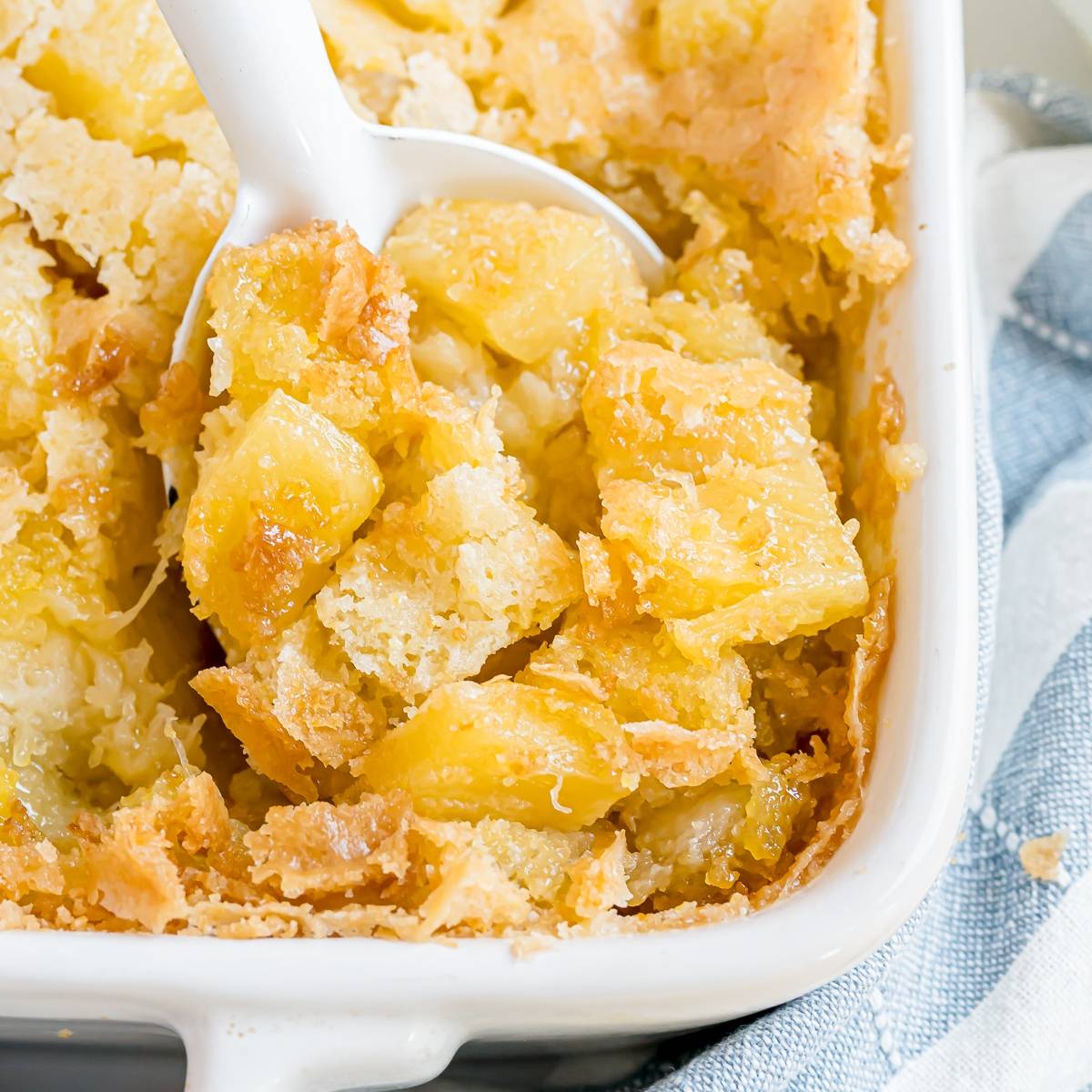 Pineapple stuffing in a white pan, with a shite spoon.
