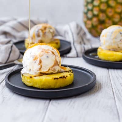 Grilled pineapple slice topped with ice cream.