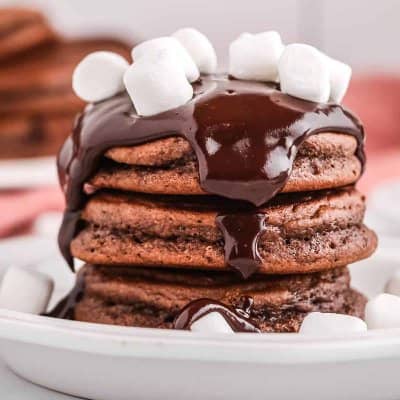 Stack of pancakes with ganache and marshmallows.
