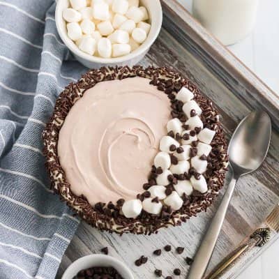 Hot chocolate dip garnished with marshmallows and chocolate chips.