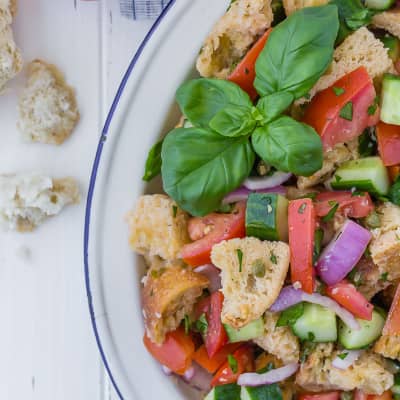 Panzanella salad topped with fresh basil.