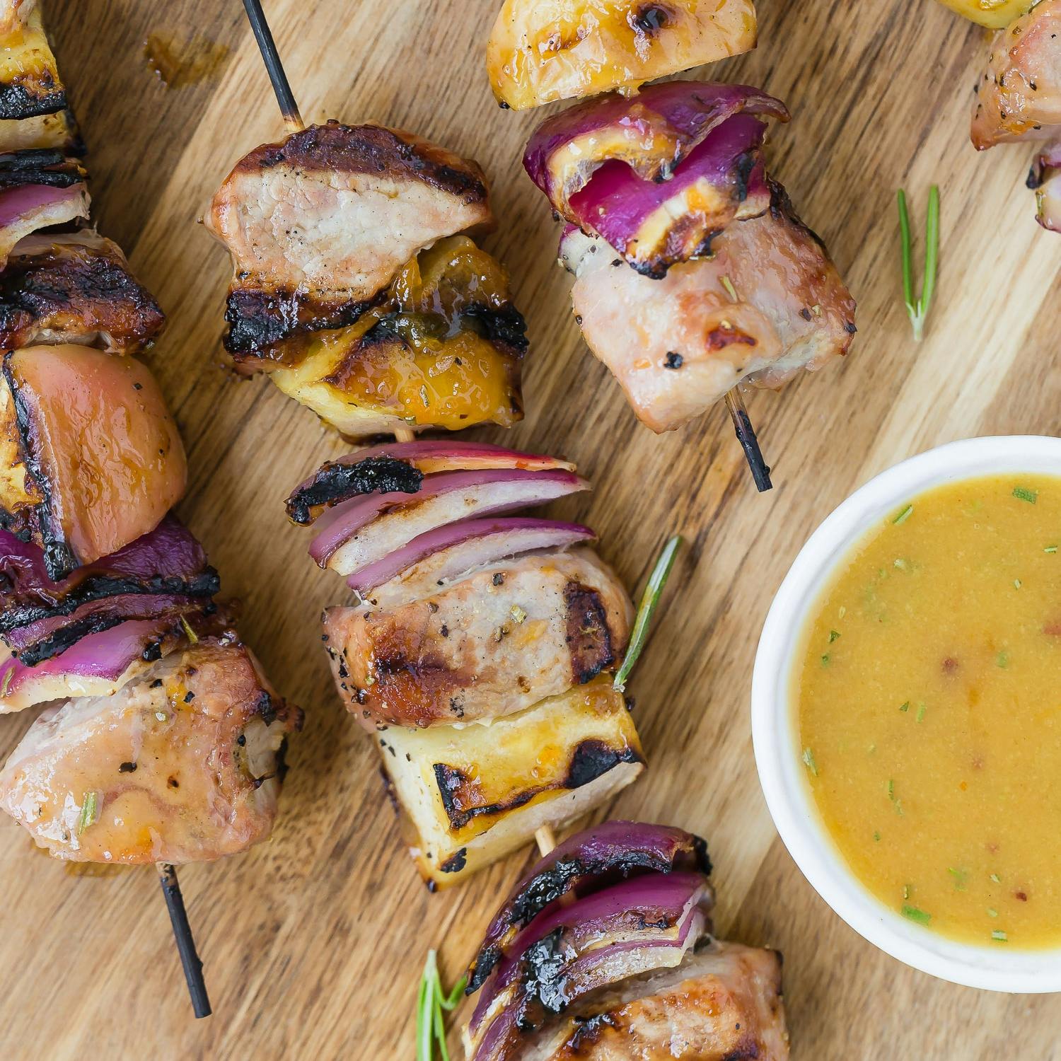 Pork kabobs on a wooden surface.