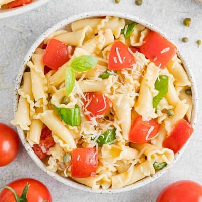 Fresh tomato pasta in white bowl.