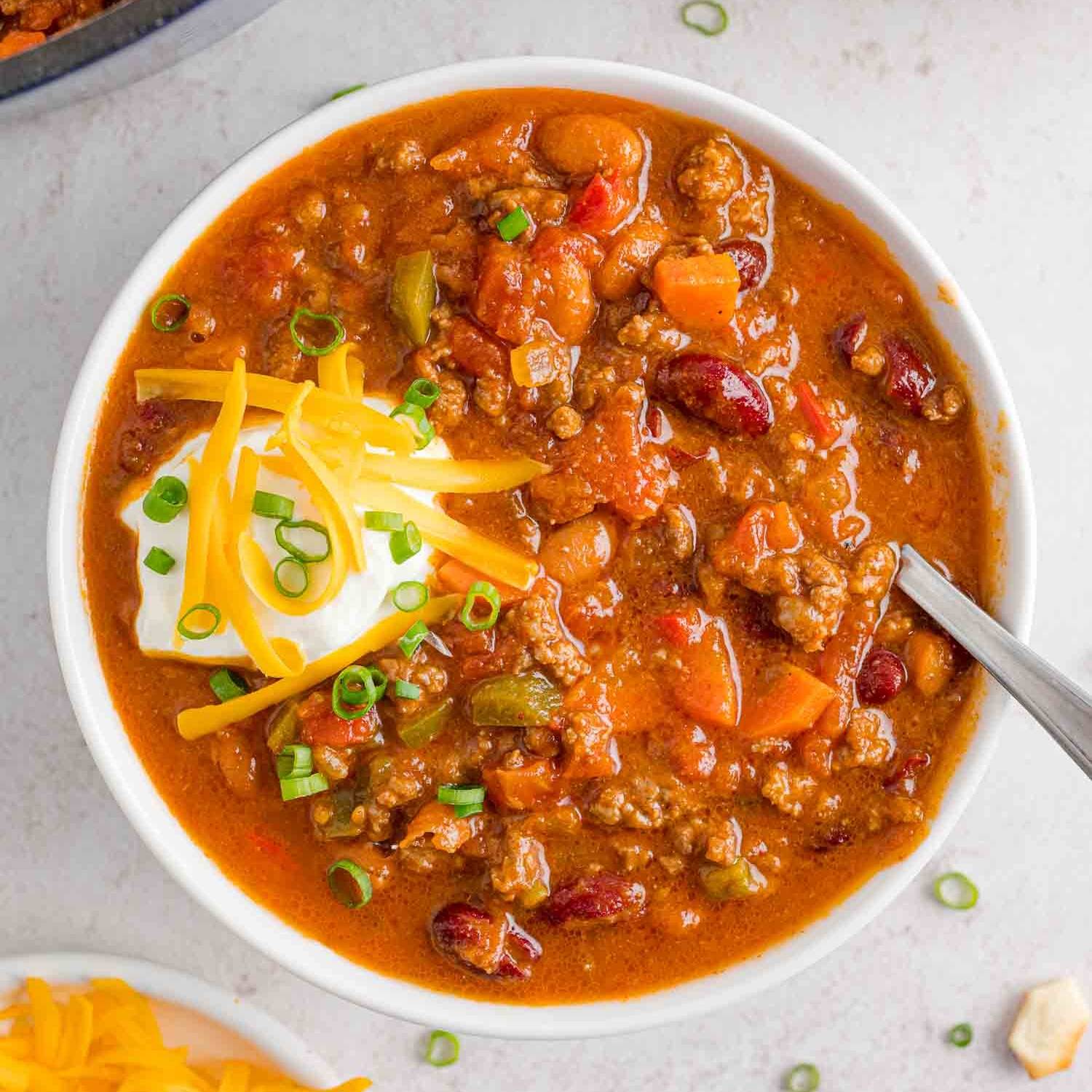 Beef chili with beans, topped with sour cream, green onions, cheddar.