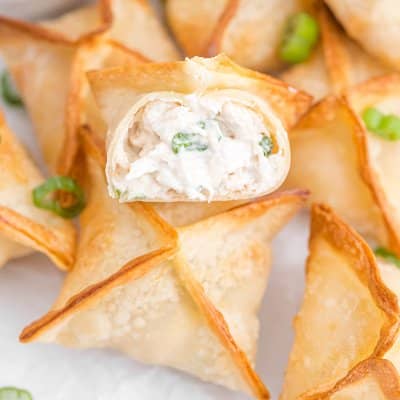 Multiple air fryer crab rangoon, one split open to show inside.
