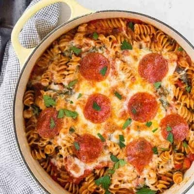 overhead view of pasta, cheese, and pepperoni in a baking dish