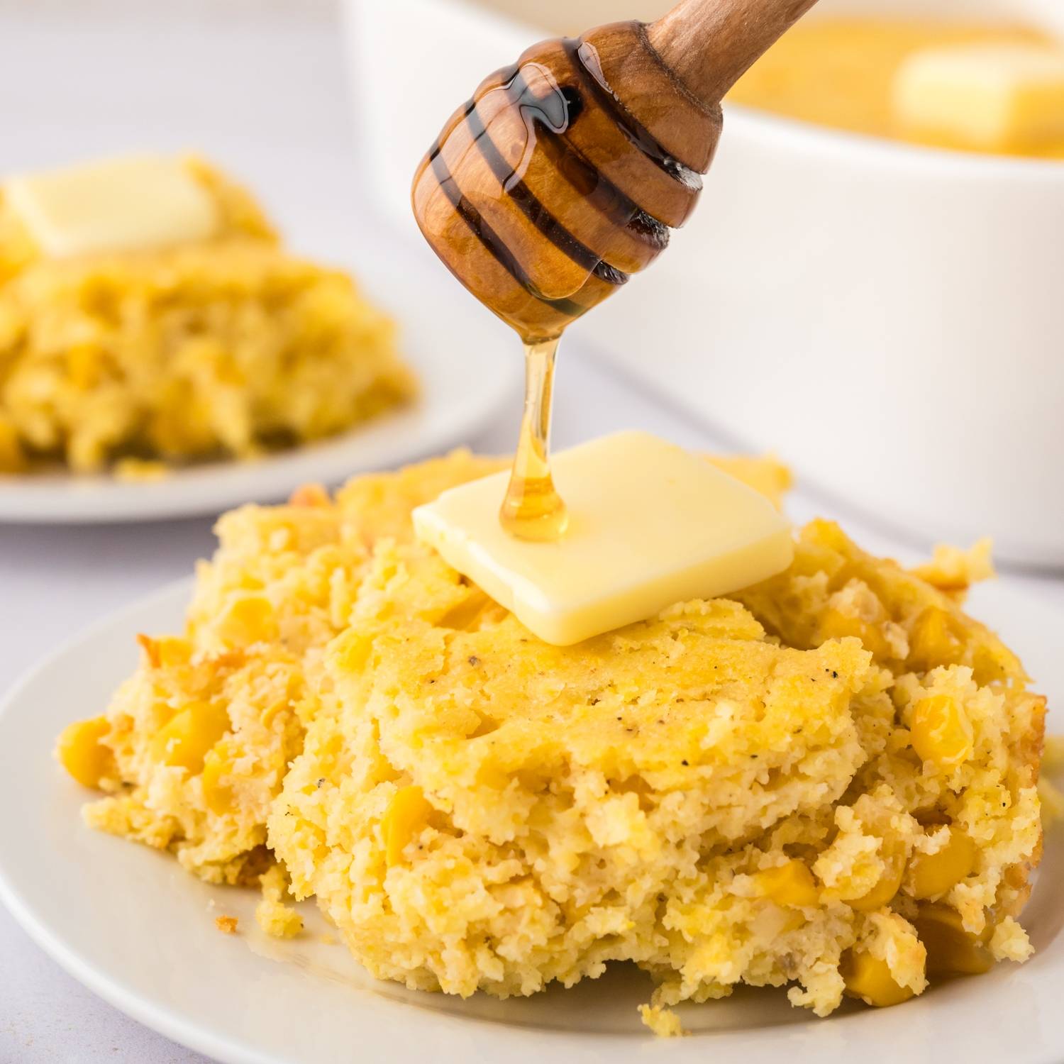Spoon bread being drizzled with honey.