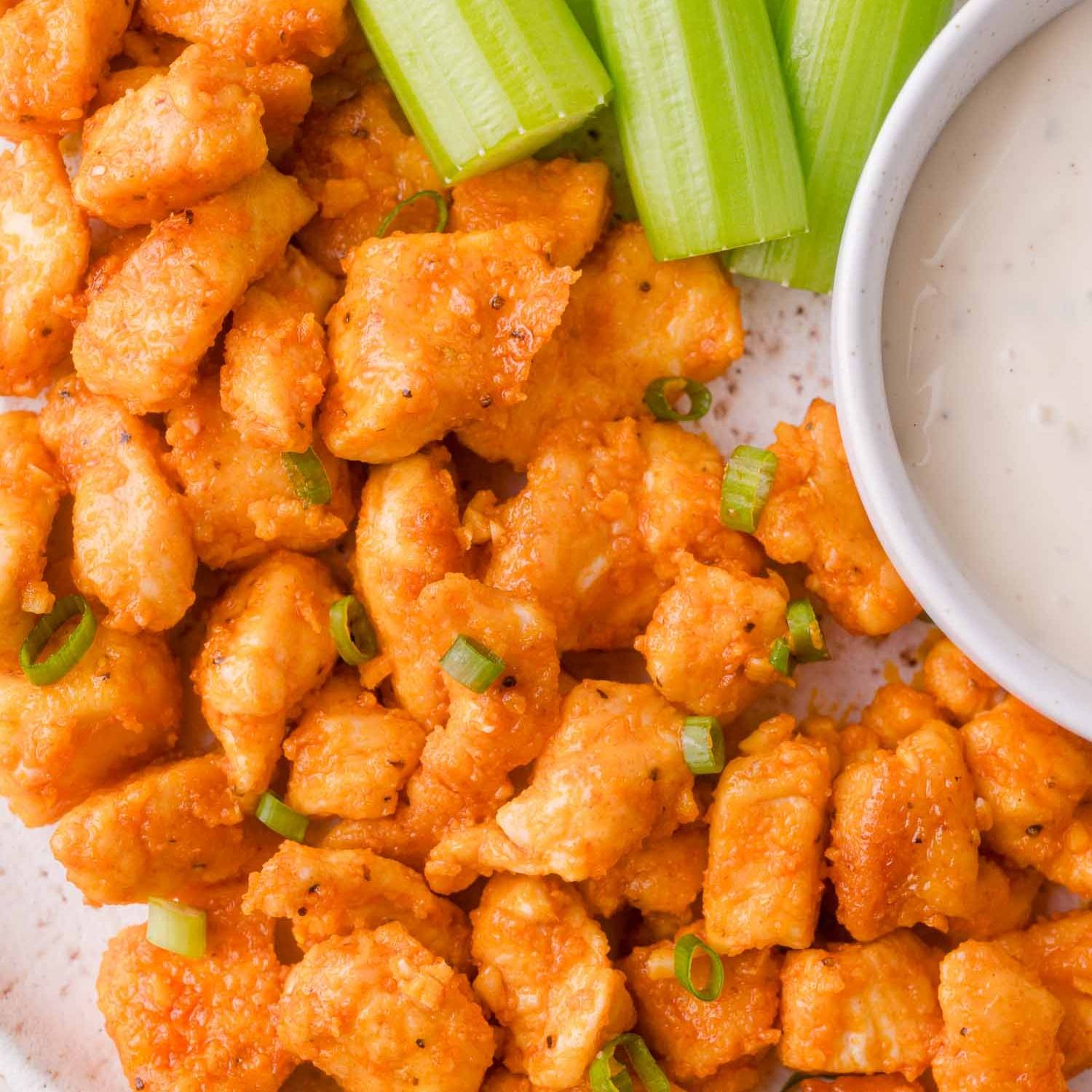 Buffalo chicken bites, with celery and ranch partially visible.