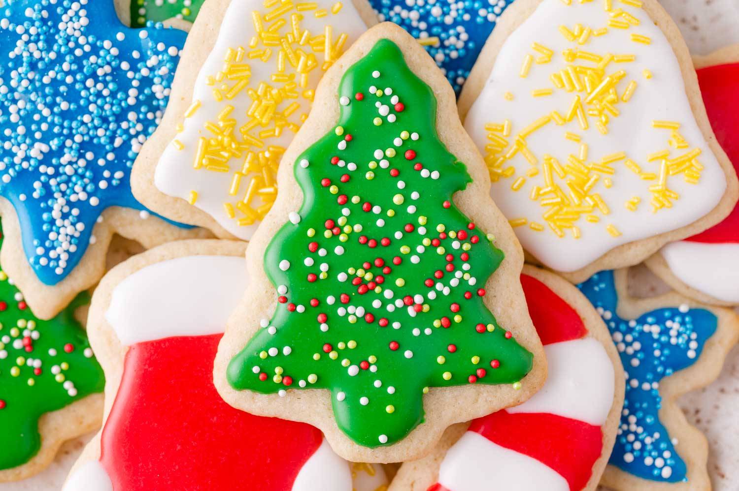 Frosted sugar cookies stacked on top of each other - Christmas trees, stars, bells.
