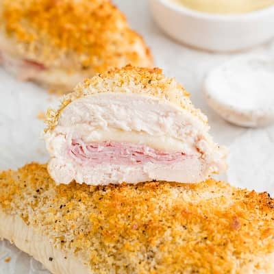 Chicken cordon bleu with breading topping, cut in half to show ham and cheese filling.