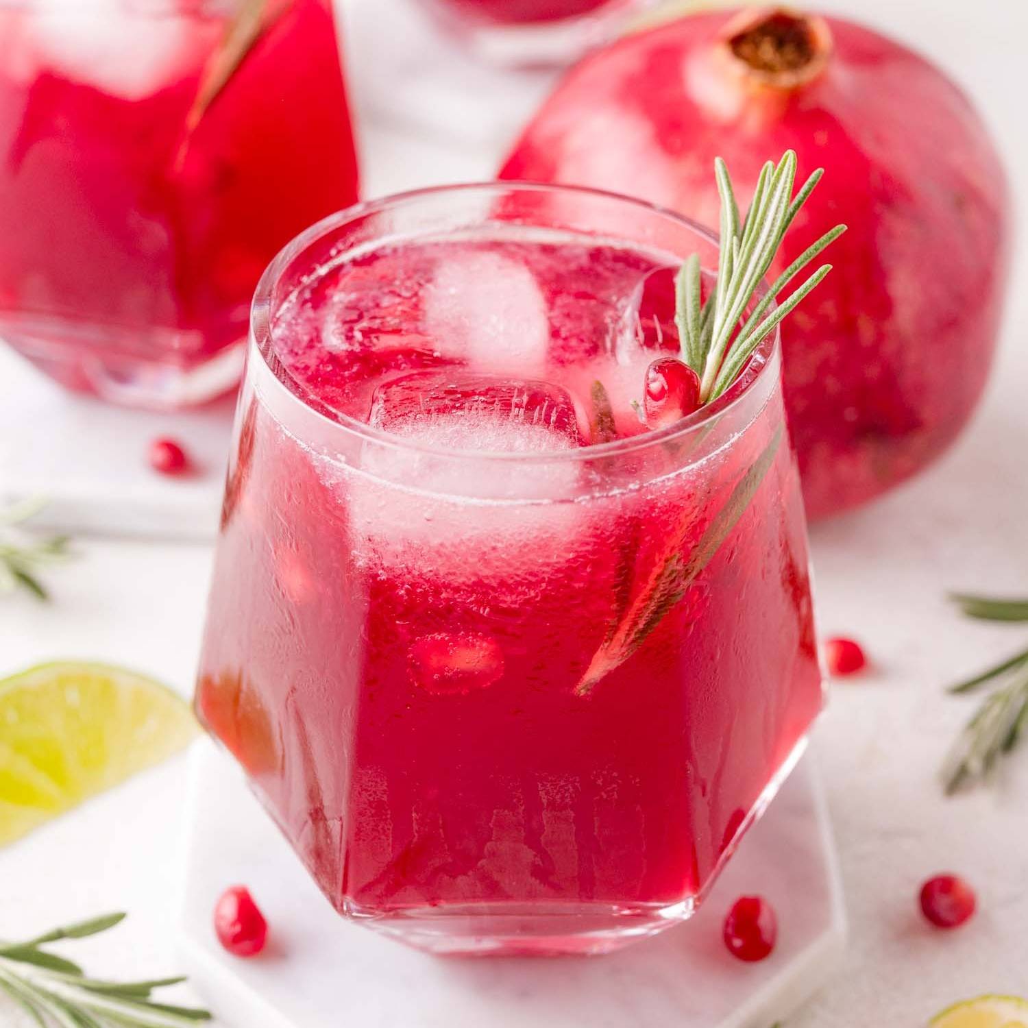 Pomegranate rosemary spritzer in a geometric glass.