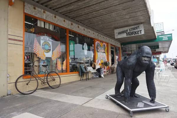 The colourful shopfront of Murray Street Market in a regional Victorian town, with a large gorilla sculpture on the footpath and a vintage bicycle leaning against the wall.
