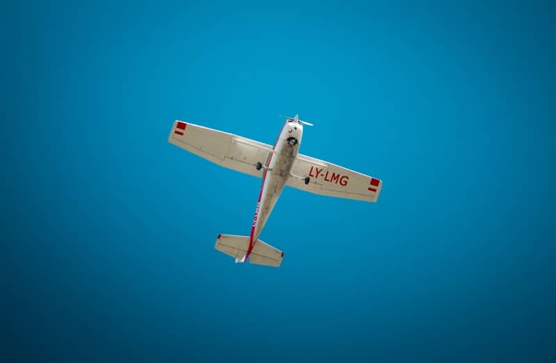 A small airplane flies against a blue sky.