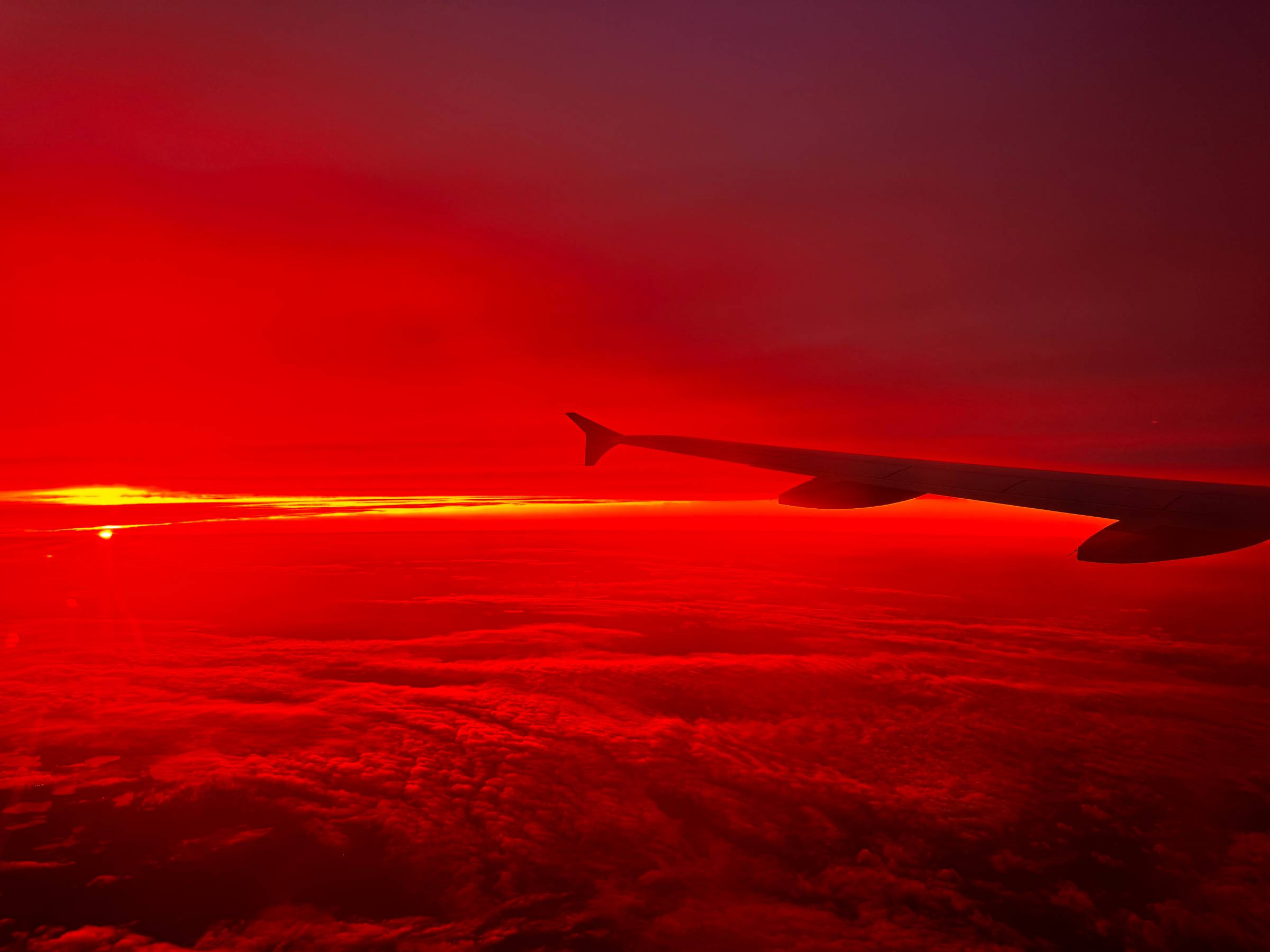 Plane wing in the sky at sunset