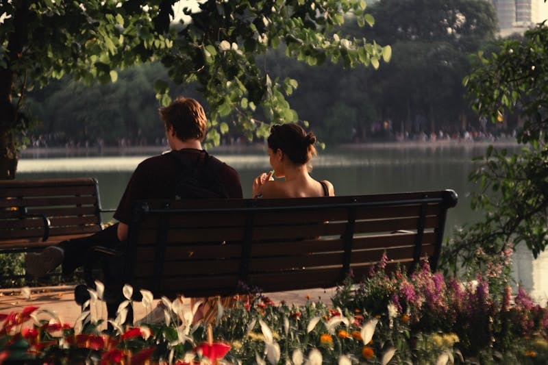 A man and a woman sitting on a park bench