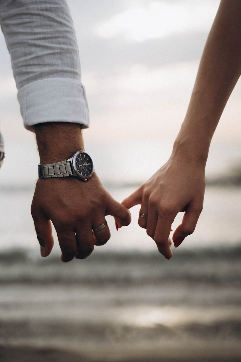 A close up of two people holding hands