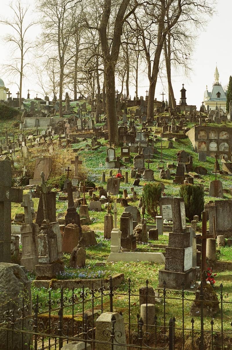 A hillside cemetery with many gravestones and crosses.