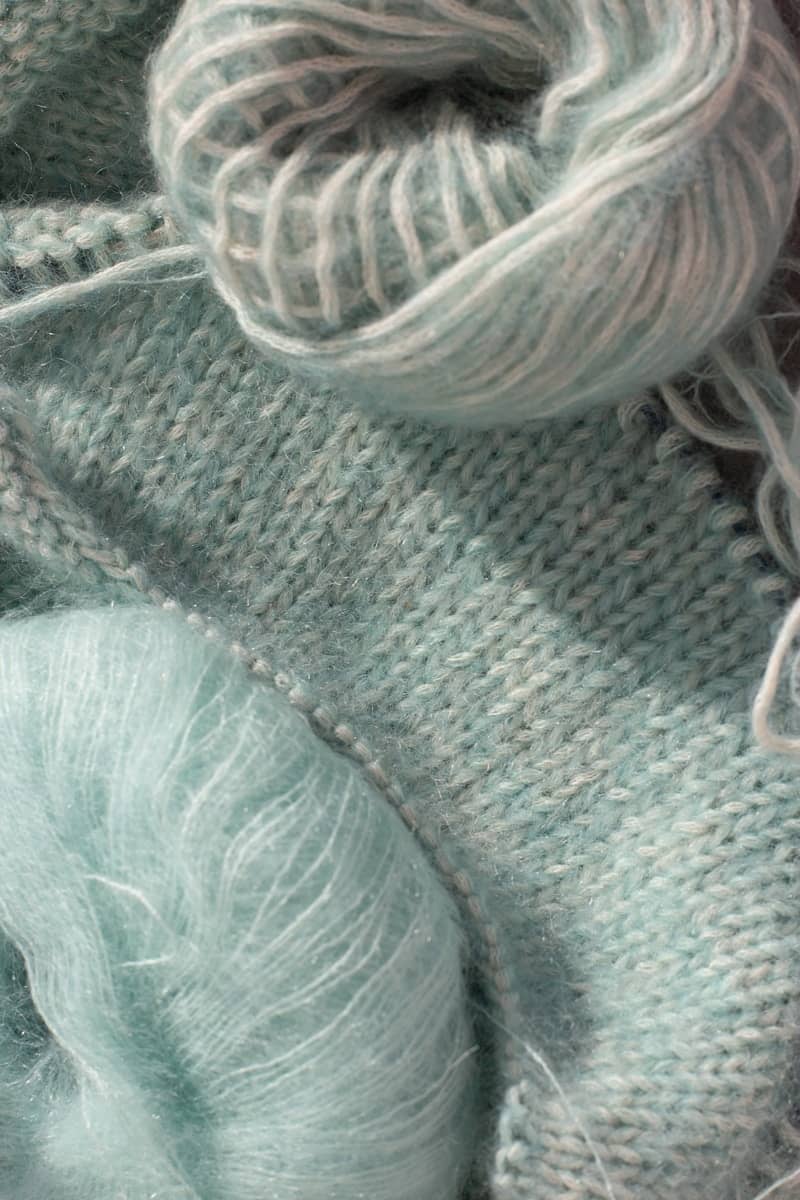 Two balls of light blue yarn and knitting